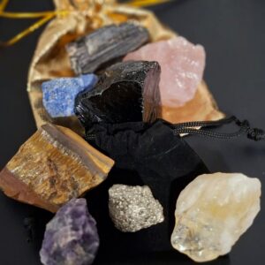 Colección de ocho minerales naturales con turmalina negra, cuarzo rosa, citrino, amatista, pirita, ojo de tigre, lapislázuli y obsidiana sobre fondo negro