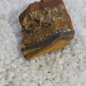 Piedra natural de Ojo de Tigre en bruto sobre fondo de sal blanca
